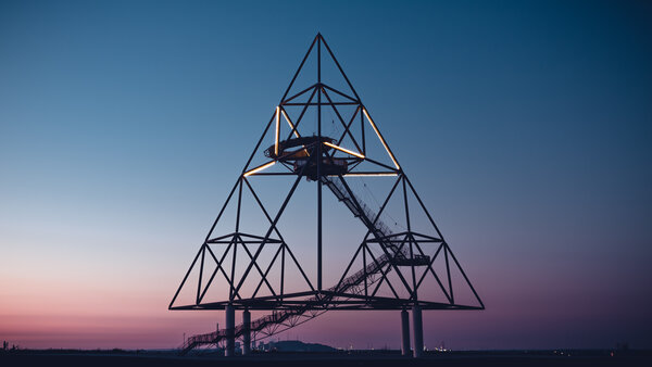 Steel structure of the tetrahedron in Bottrop at dusk, with staircase and illuminated struts.