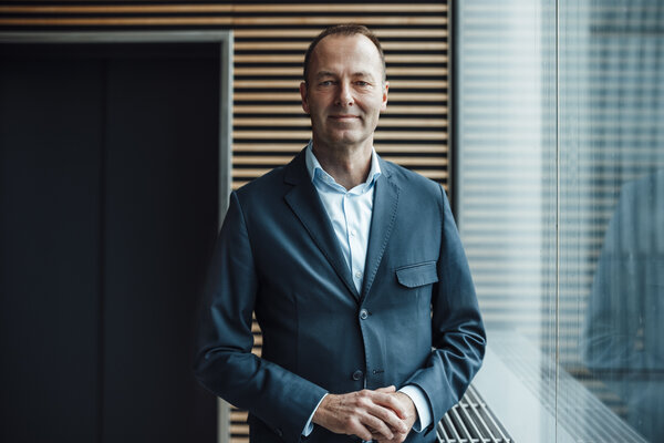 A portrait photograph of a man wearing a light blue shirt and a dark-coloured jacket.