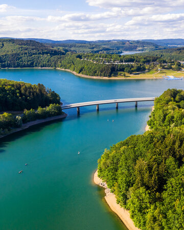 [Translate to 中文:] Aerial view of Biggesee lake with shoreline and bridge in South Westphalia.